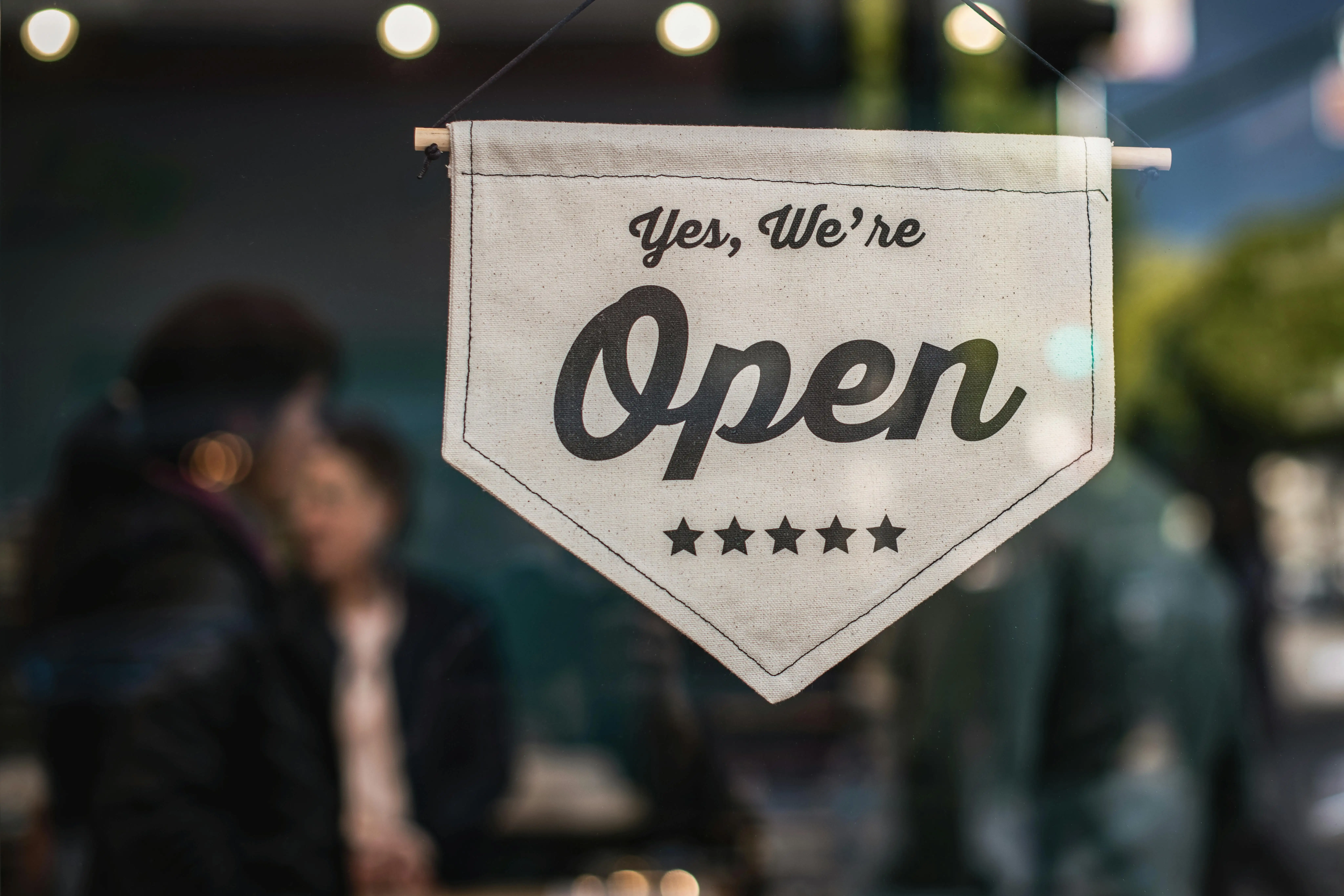 Close-up of a 'Yes, We're Open' banner, illustrating the successful reinstatement of an LLC or Corporation