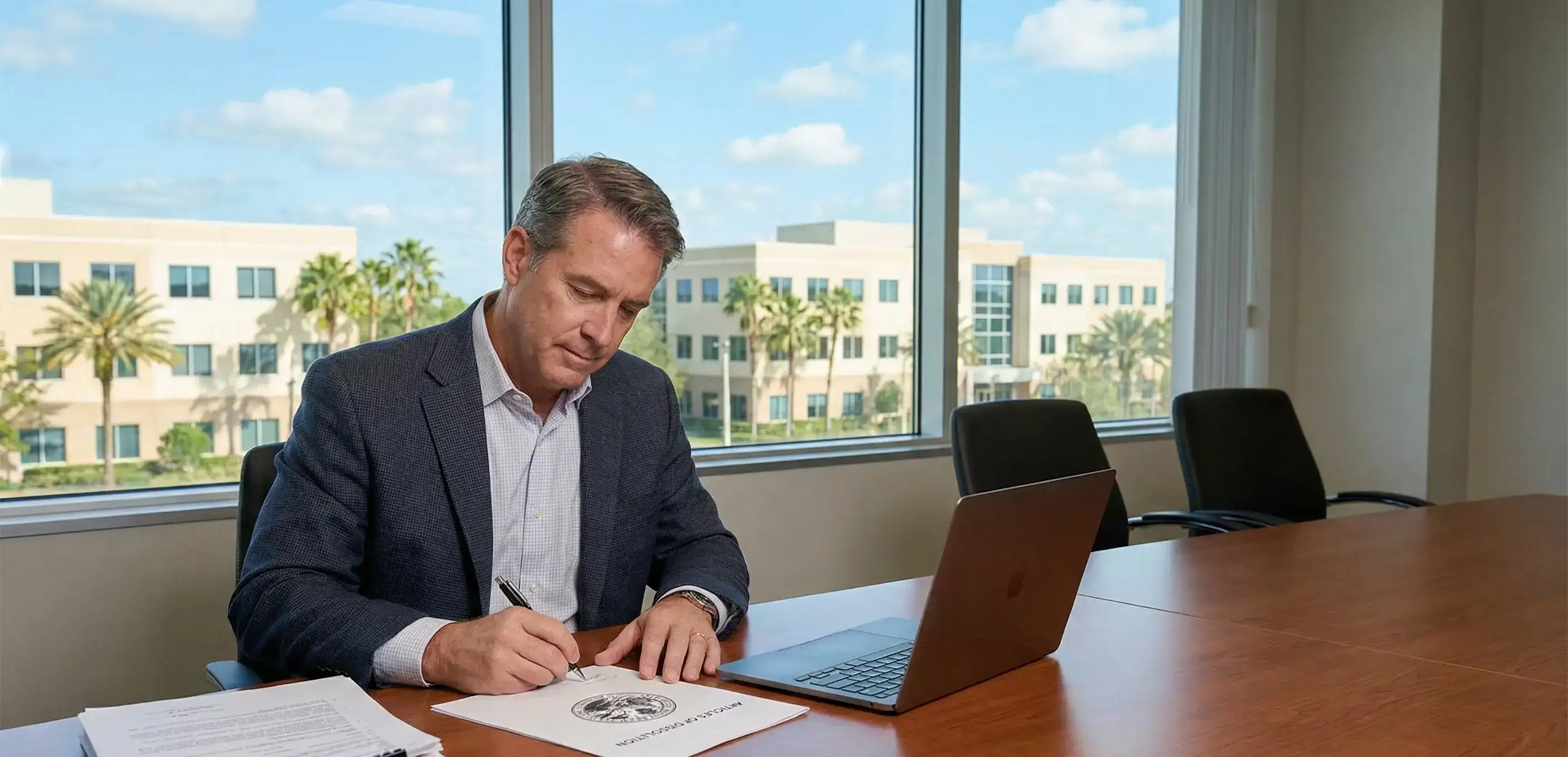 A business owner at a conference table signing the Articles of Dissolution to legally dissolve a corporation in Florida.